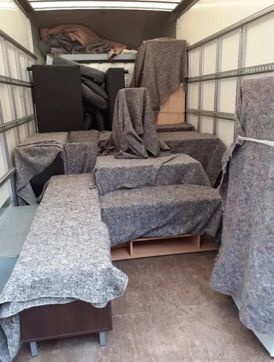 Items wrapped in protective blankets inside a Stafford Removals van